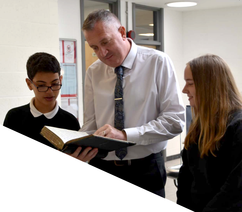Headteacher and Students look at a book